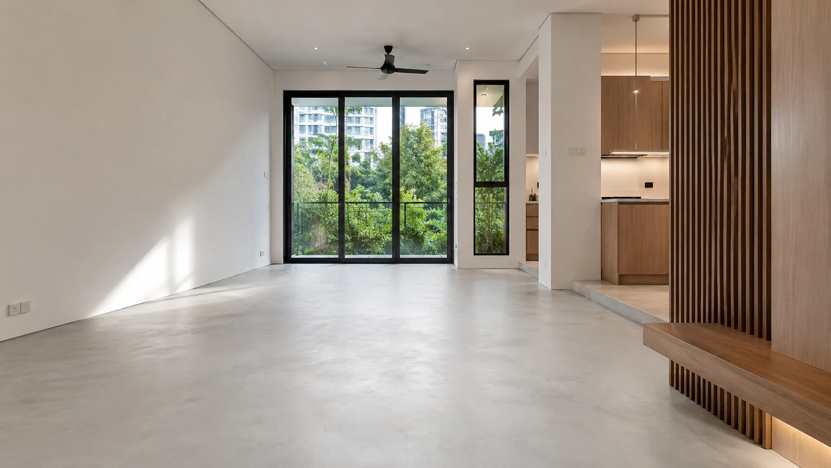 Condo living and dining area finished with a seamless grey polished cement screed floor, opening onto a covered outdoor patio