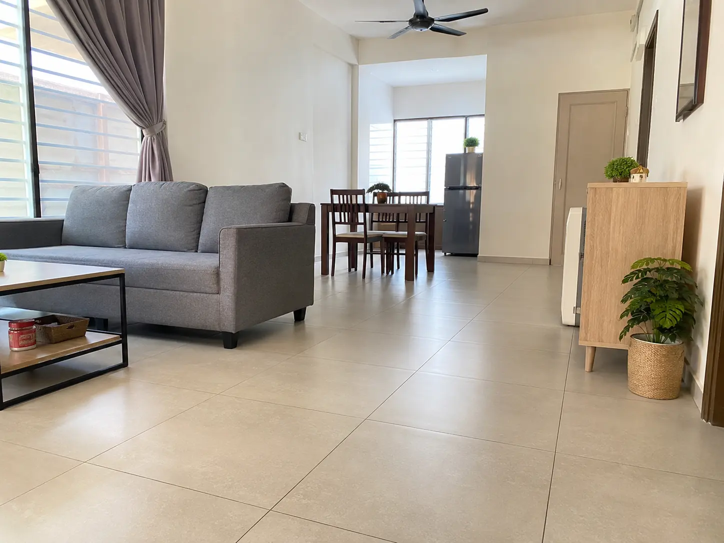 Open-plan living and dining area with large-format light-toned floor tiles