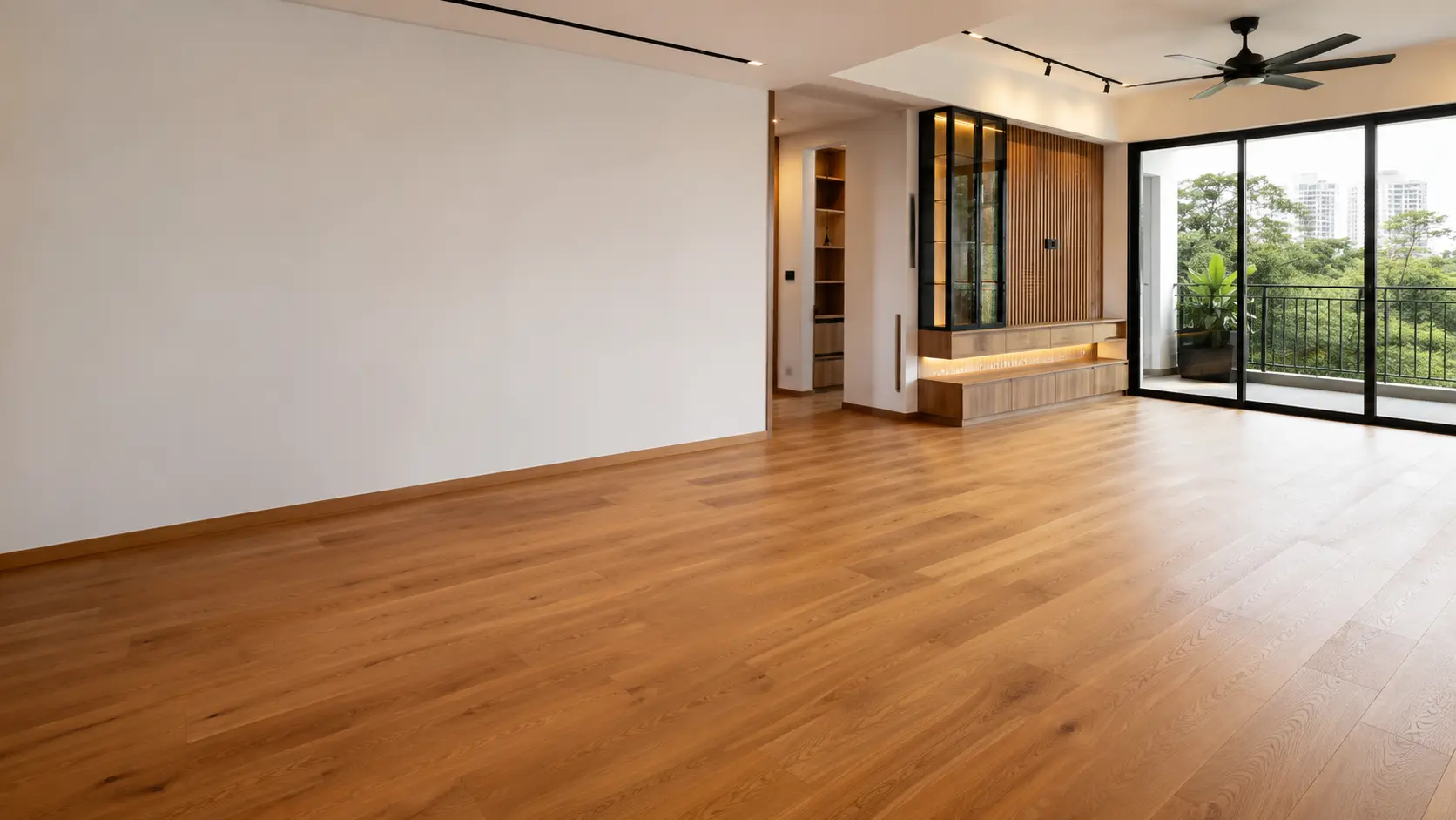 Condo living room with warm-toned wide-plank wood flooring